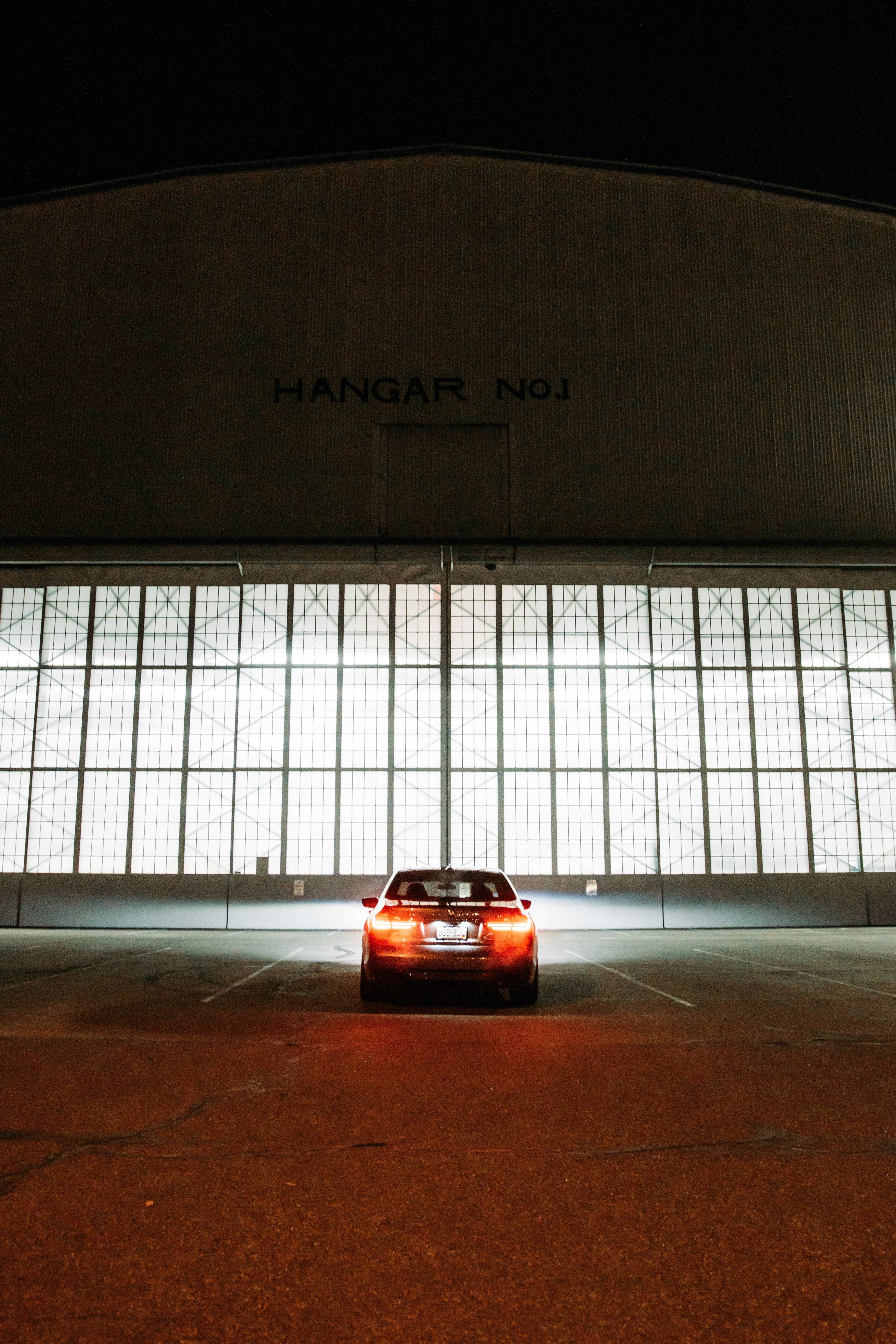 red car parked in front of white wall